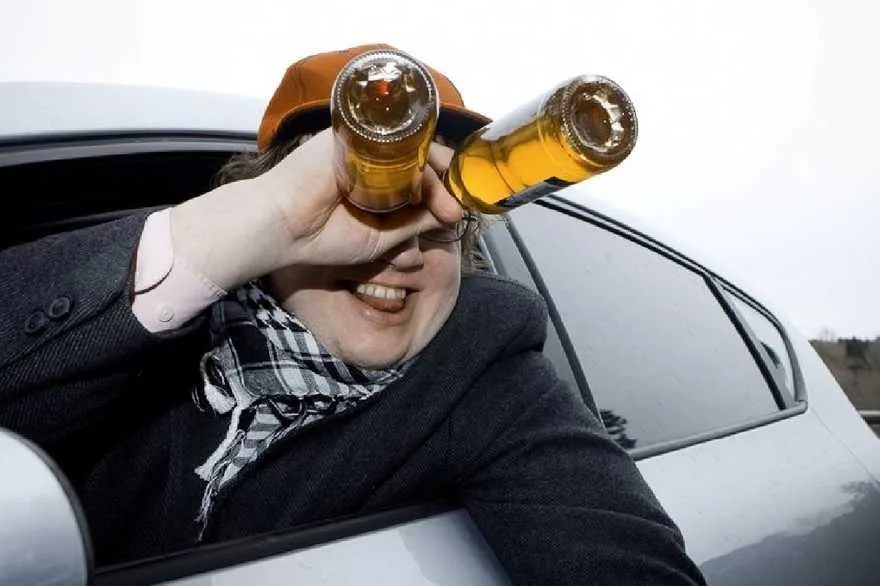 Чоловік дивиться крізь пляшки з авто