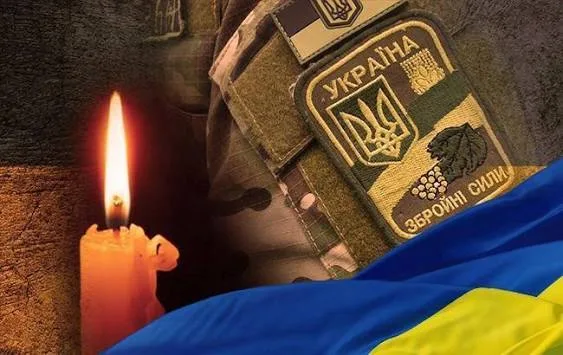 Свічка пам’яті та емблема Збройних Сил України