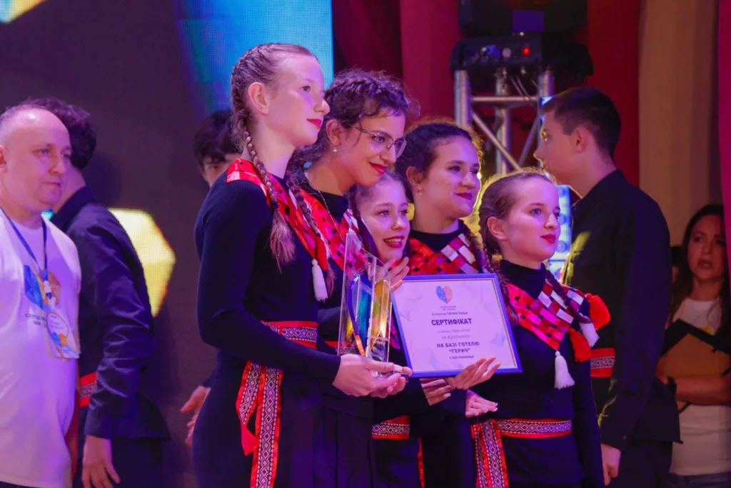 Дівчата отримують сертифікат на сцені конкурсу