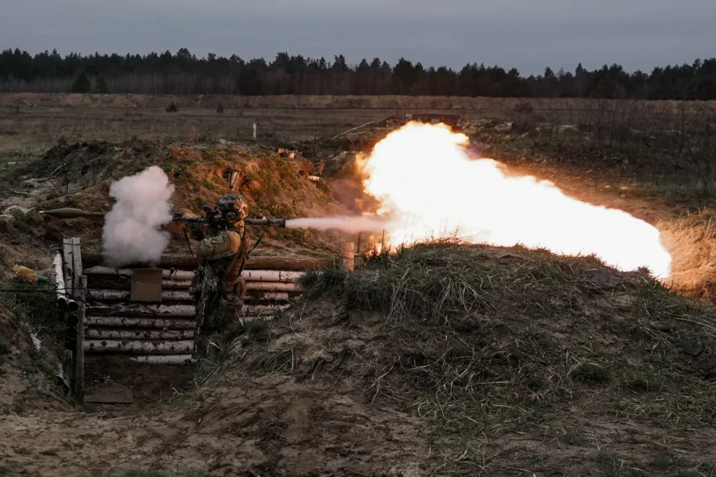 Військовий стріляє з гранатомета на полі бою