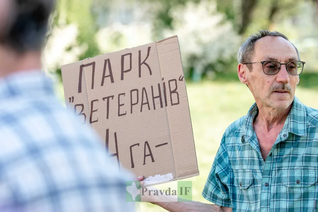 Чоловік тримає плакат з написом Парк ветеранів