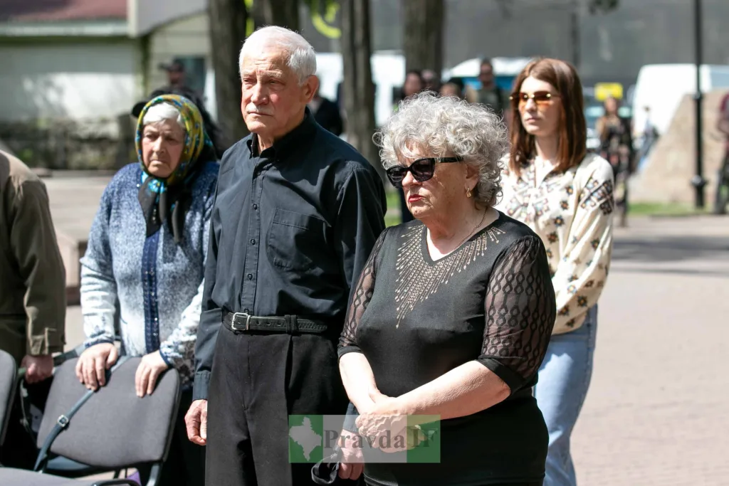 Люди стоять на вулиці під час заходу пам’яті