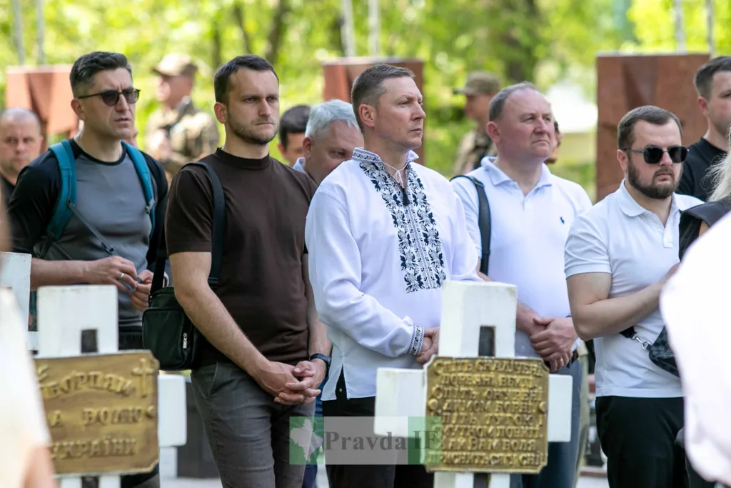 Люди вшановують пам'ять на військовому цвинтарі