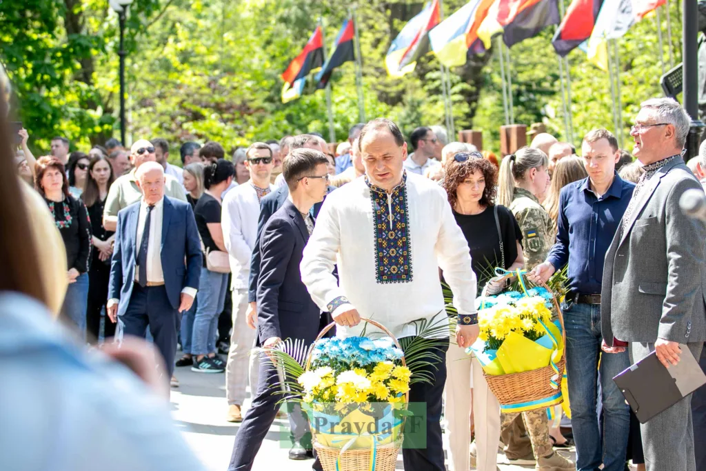 Люди у вишиванках несуть квіти на церемонії