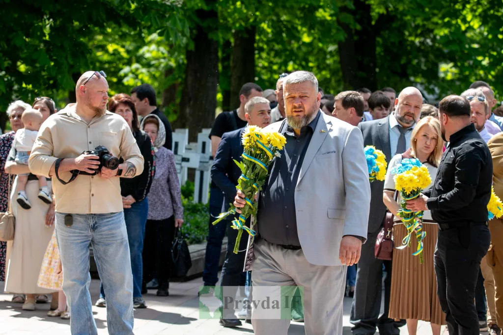 Люди з квітами під час пам’ятного заходу