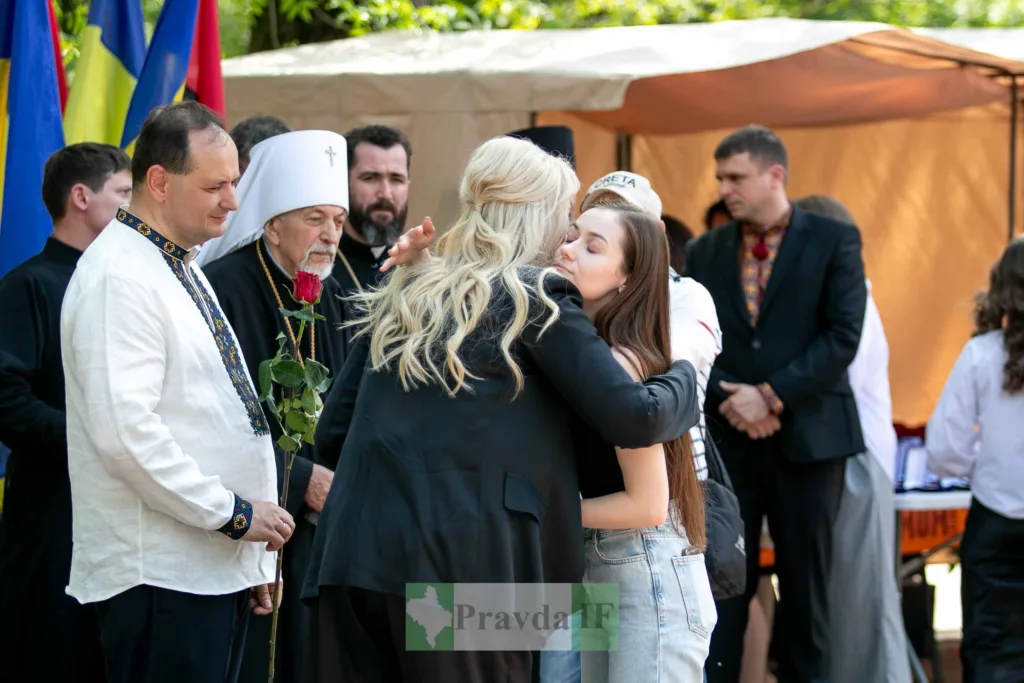 Люди обіймаються під час урочистого заходу