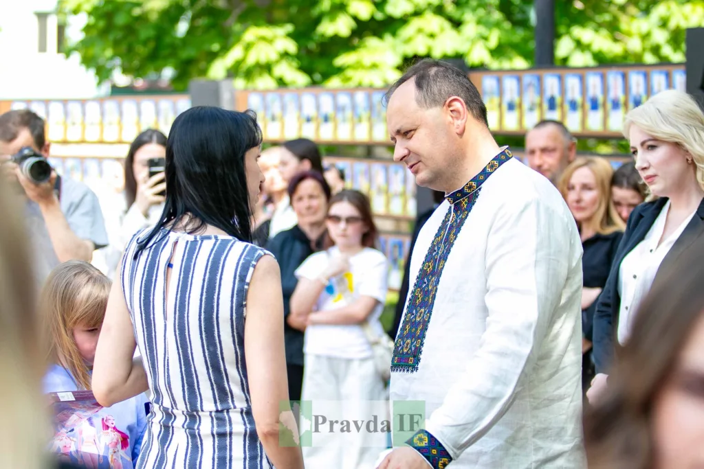 Люди спілкуються на вуличному заході у вишиванках