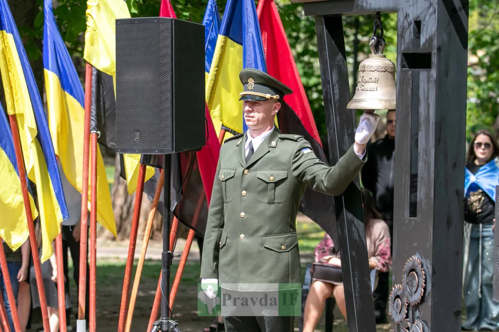 Військовий дзвонить у дзвін під українськими прапорами
