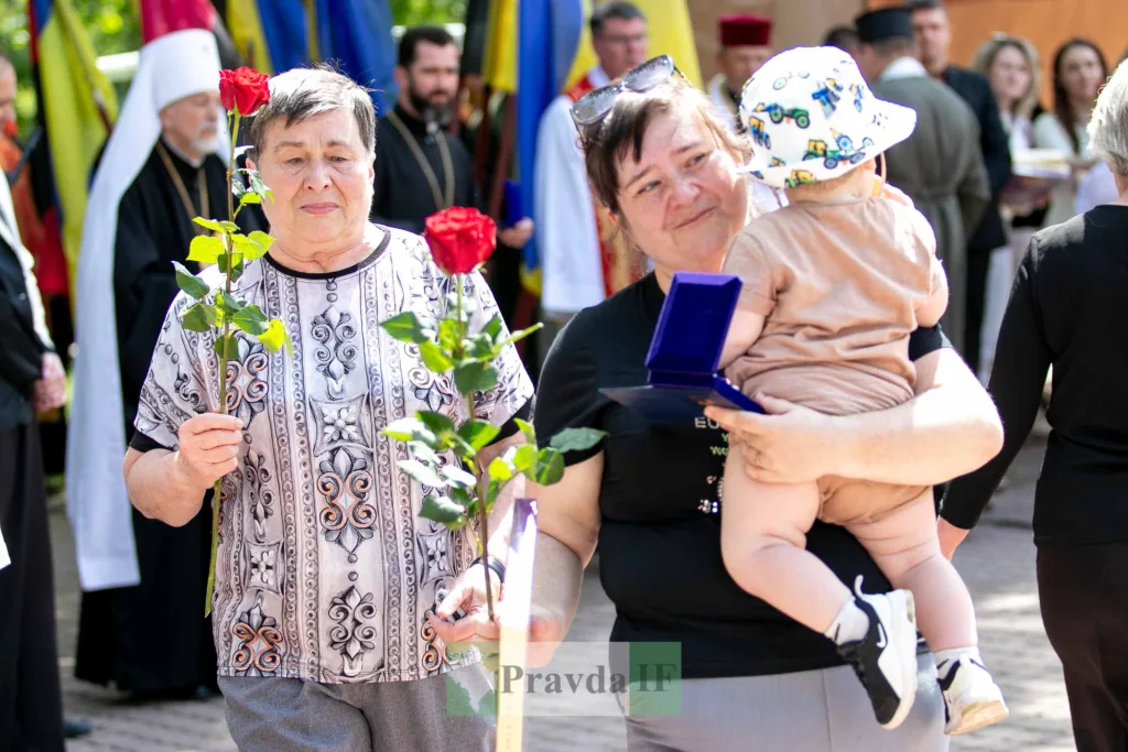 Жінки з дитиною тримають троянди на церемонії
