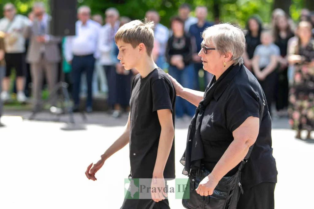 Жінка підтримує хлопчика під час події надворі