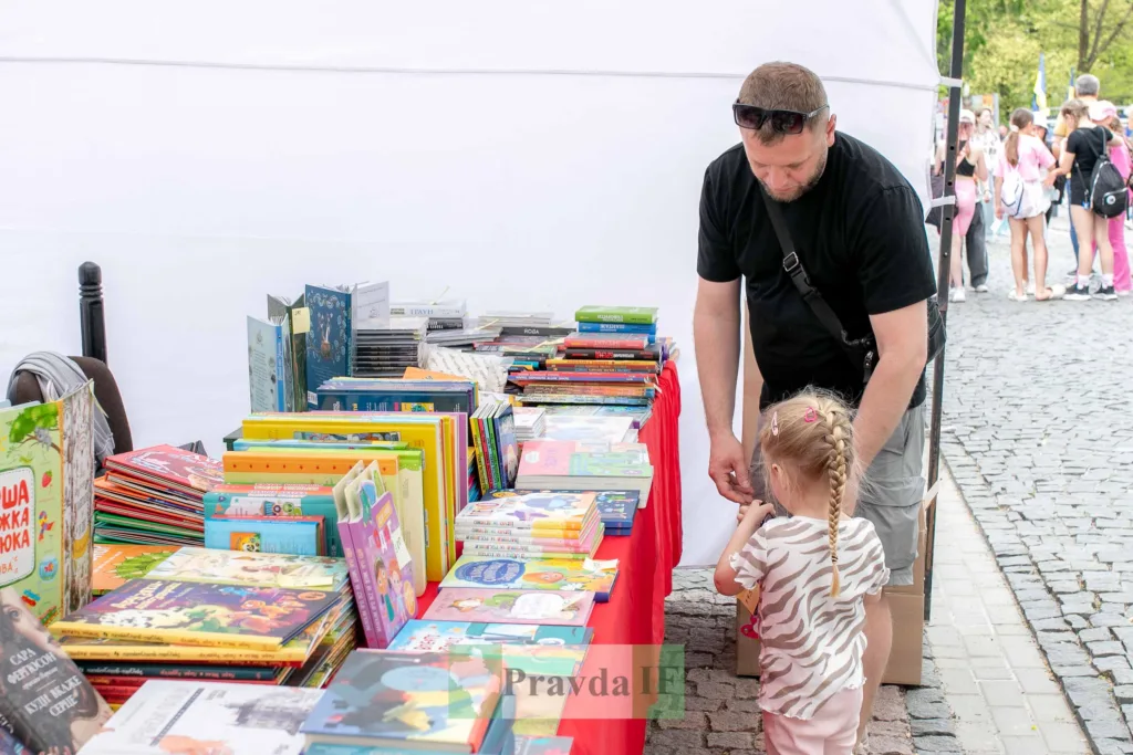 Чоловік і дитина вибирають книги на ярмарку
