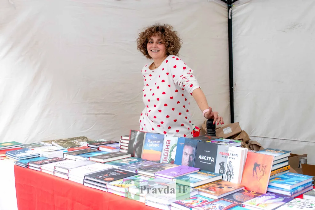 Жінка продає книги на книжковому ярмарку