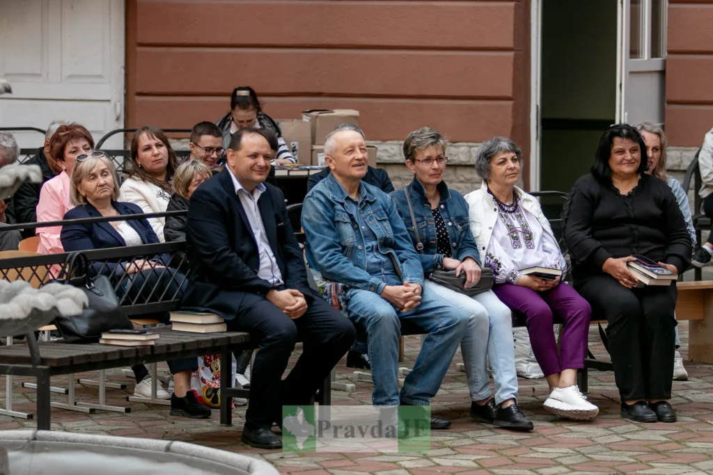 Люди сидять на вуличному літературному заході