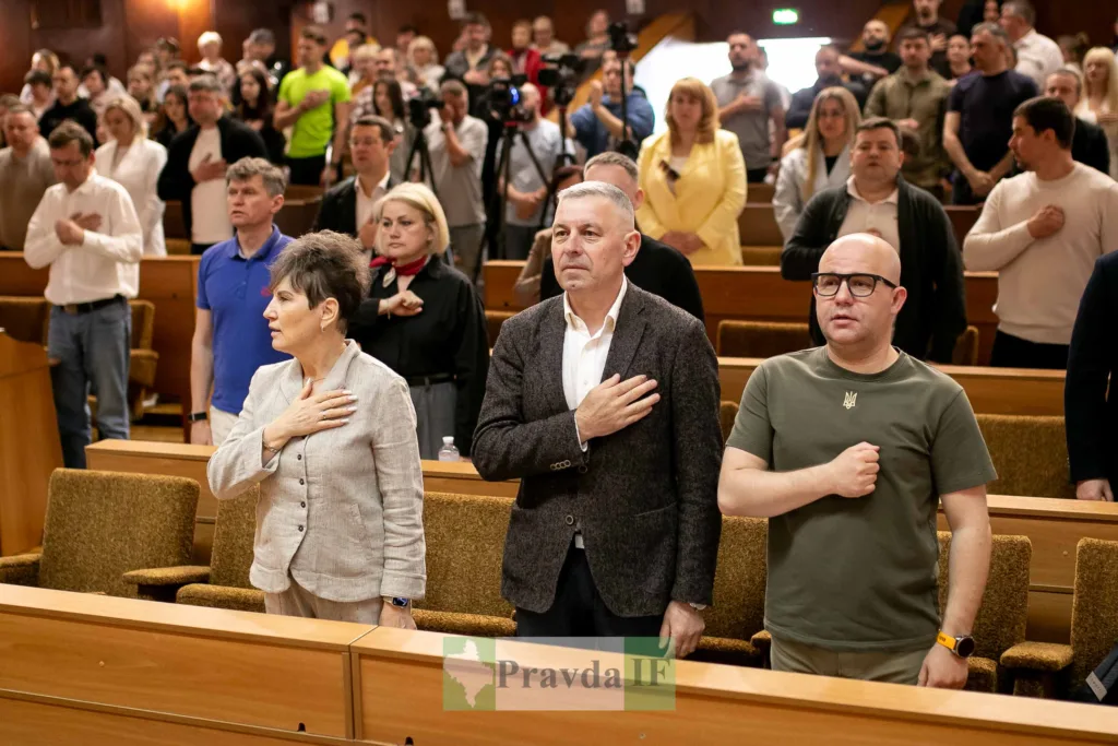 Люди стоять у залі з рукою на серці