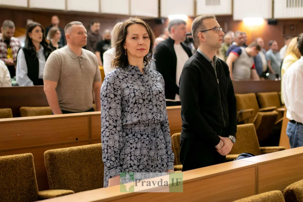 Люди стоять у залі під час зборів