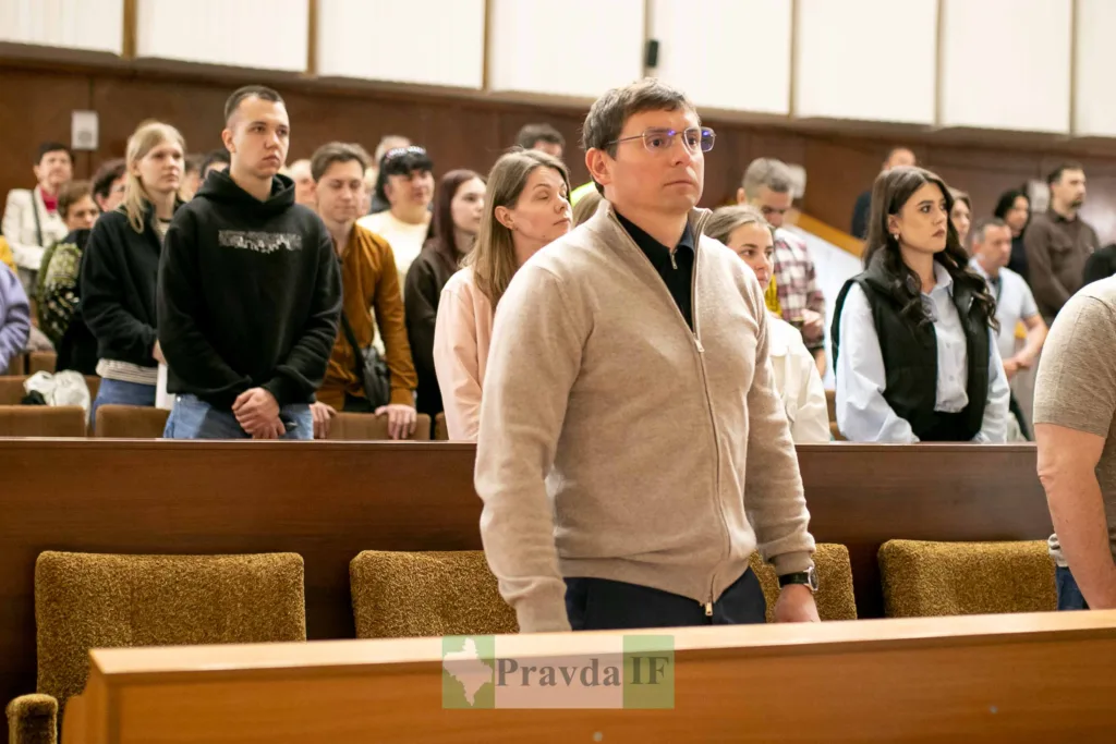 Люди стоять у залі під час заходу