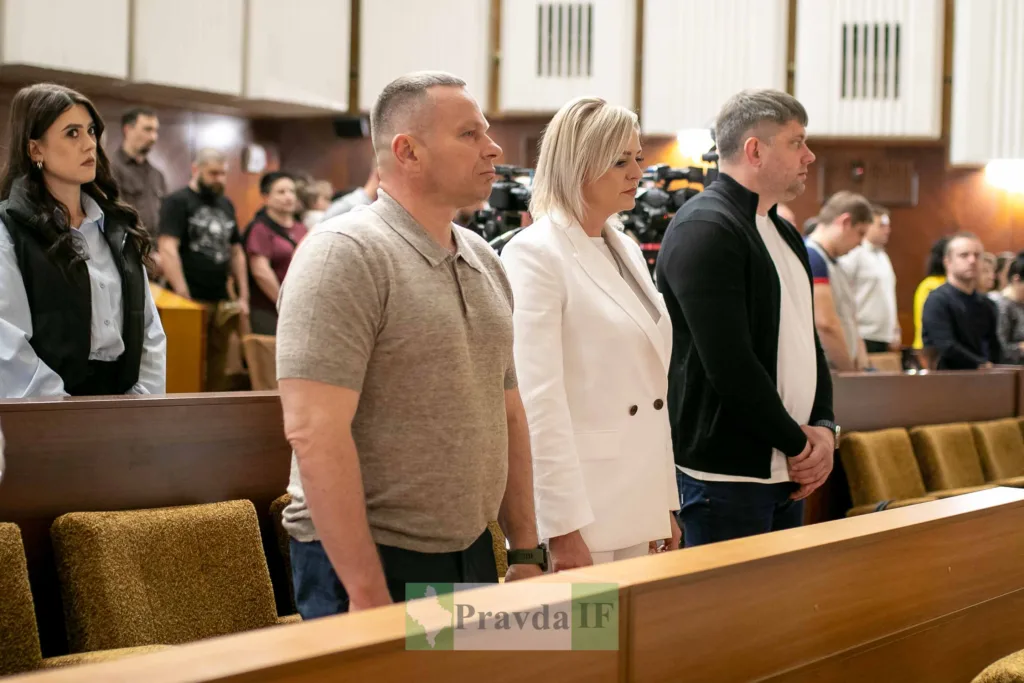 Люди стоять під час засідання в залі