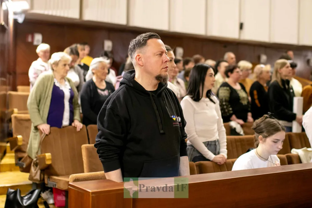 Люди стоять у залі під час заходу