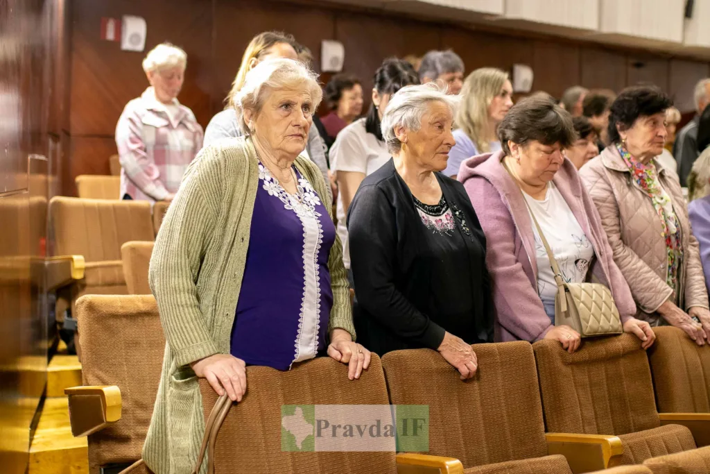 Люди стоять у залі під час заходу