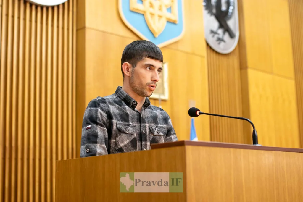 Чоловік виступає на трибуні у залі засідань