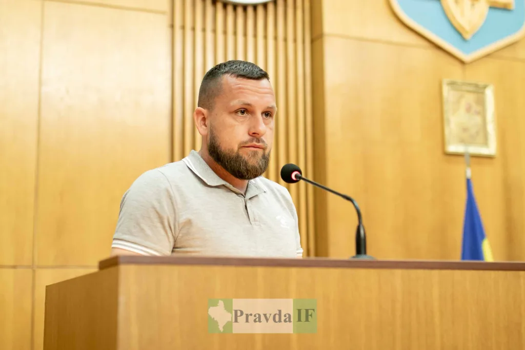 Чоловік виступає на трибуні в залі засідань