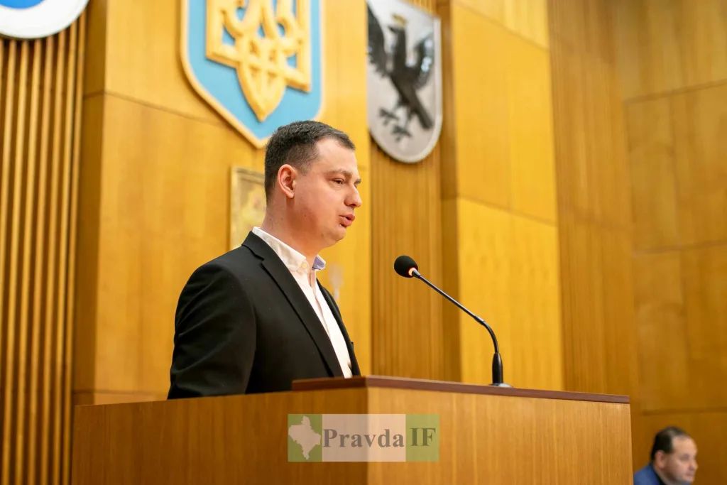 Чоловік виступає на трибуні у залі засідань