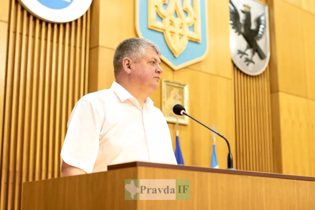 Чоловік виступає на трибуні в залі засідань