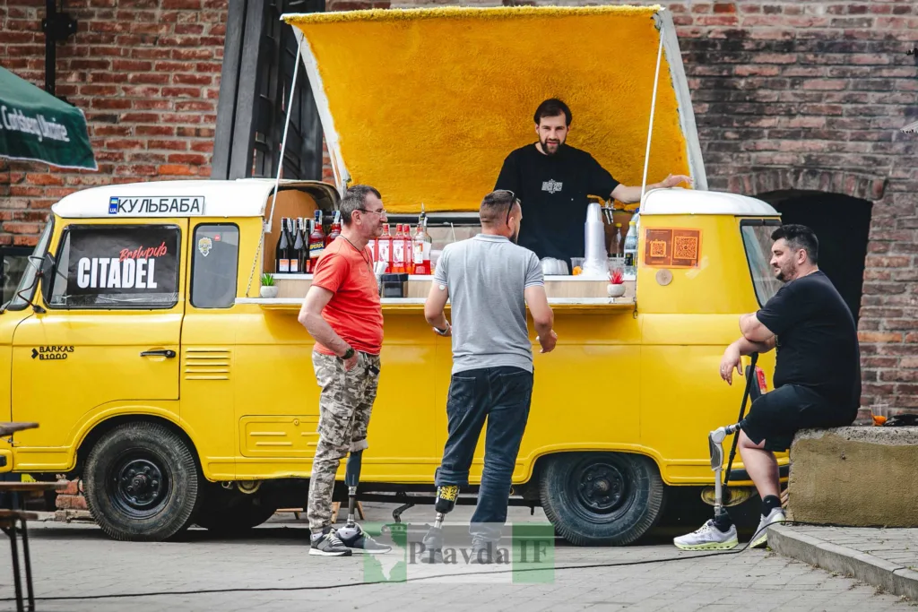 Люди біля жовтого фудтрака на вулиці