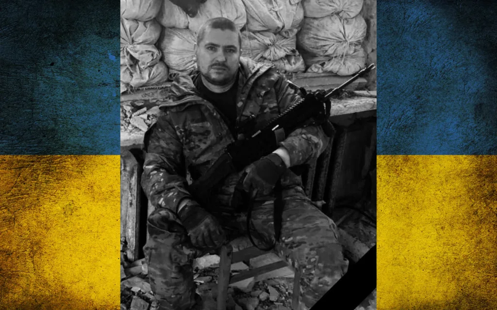 Український військовий у камуфляжі з прапором України
