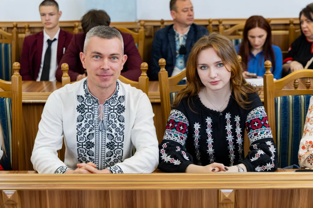 Люди у вишиванках сидять у залі