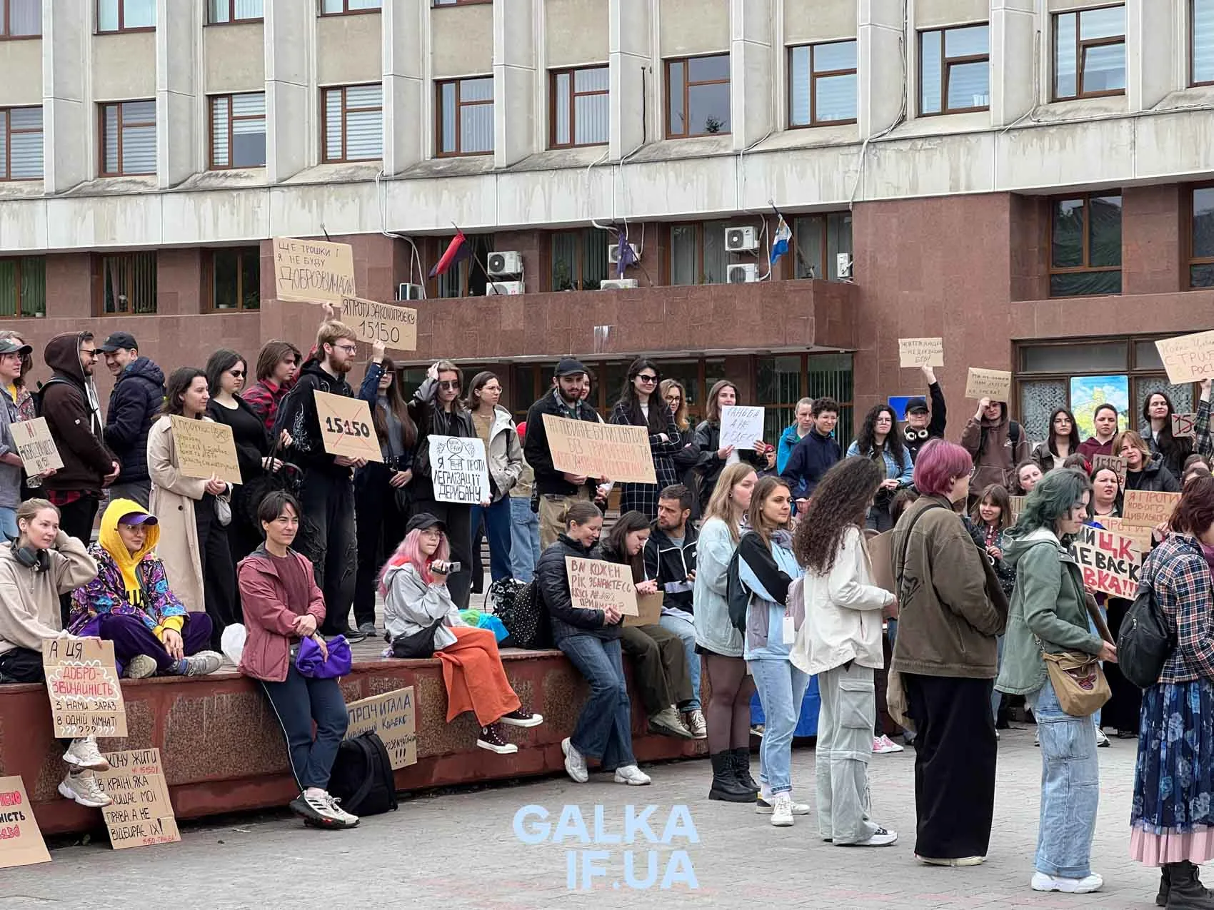 Мітинг людей із плакатами перед будівлею міськради