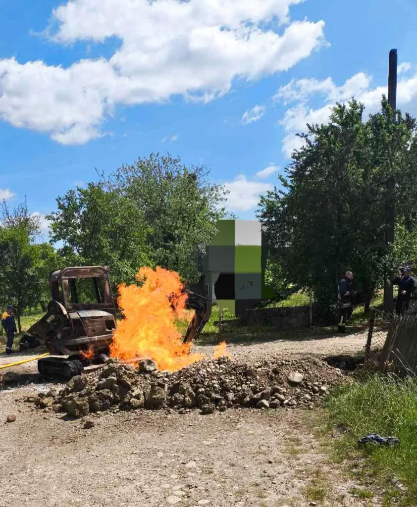 Палаючий екскаватор на сільській дорозі