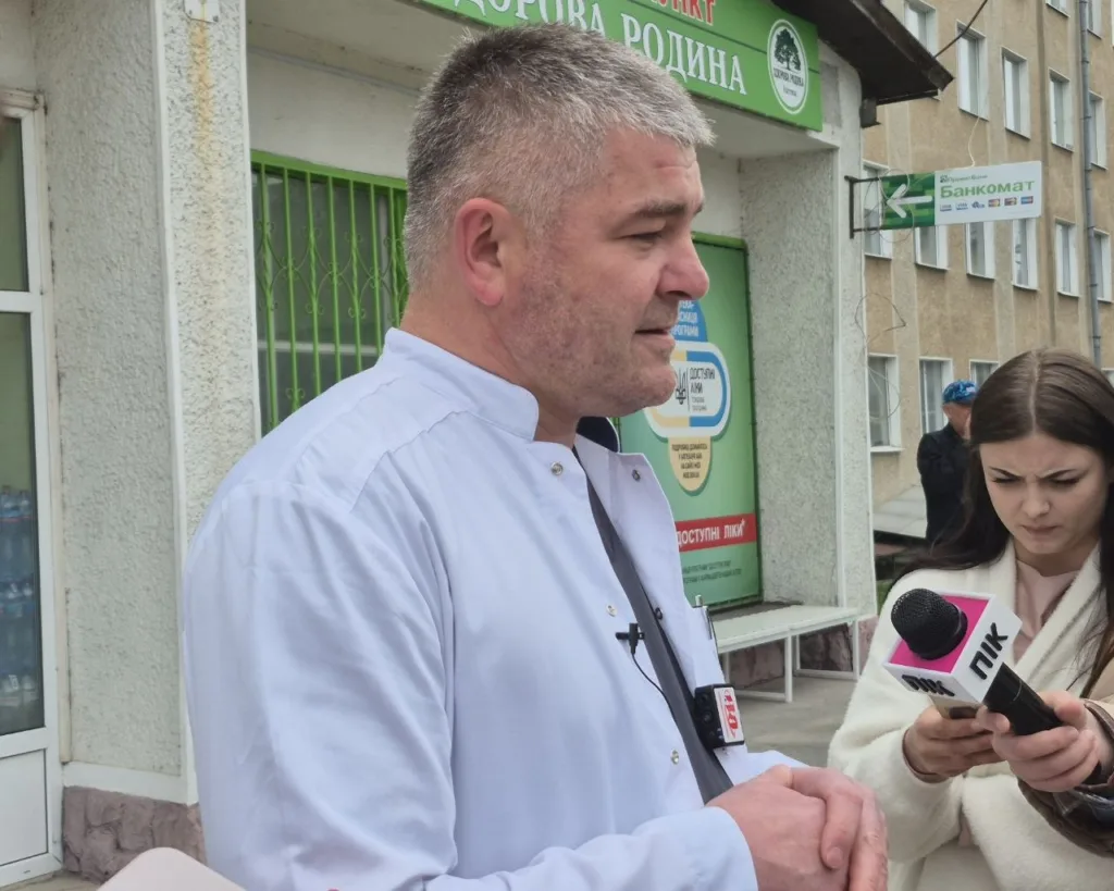 Лікар дає інтерв'ю журналістці біля аптеки