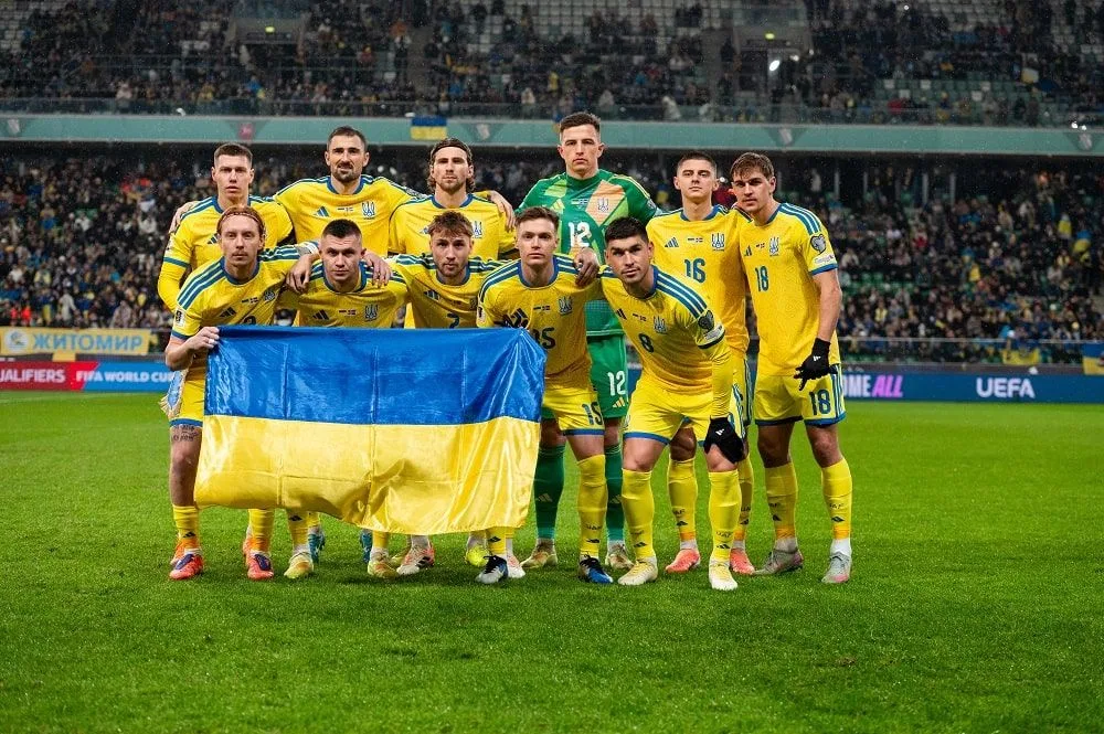 Збірна України з футболу з прапором на полі