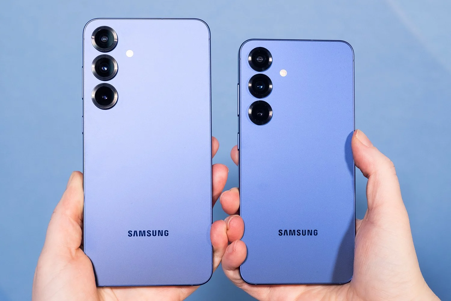 Два смартфони Samsung фіолетового кольору в руках
