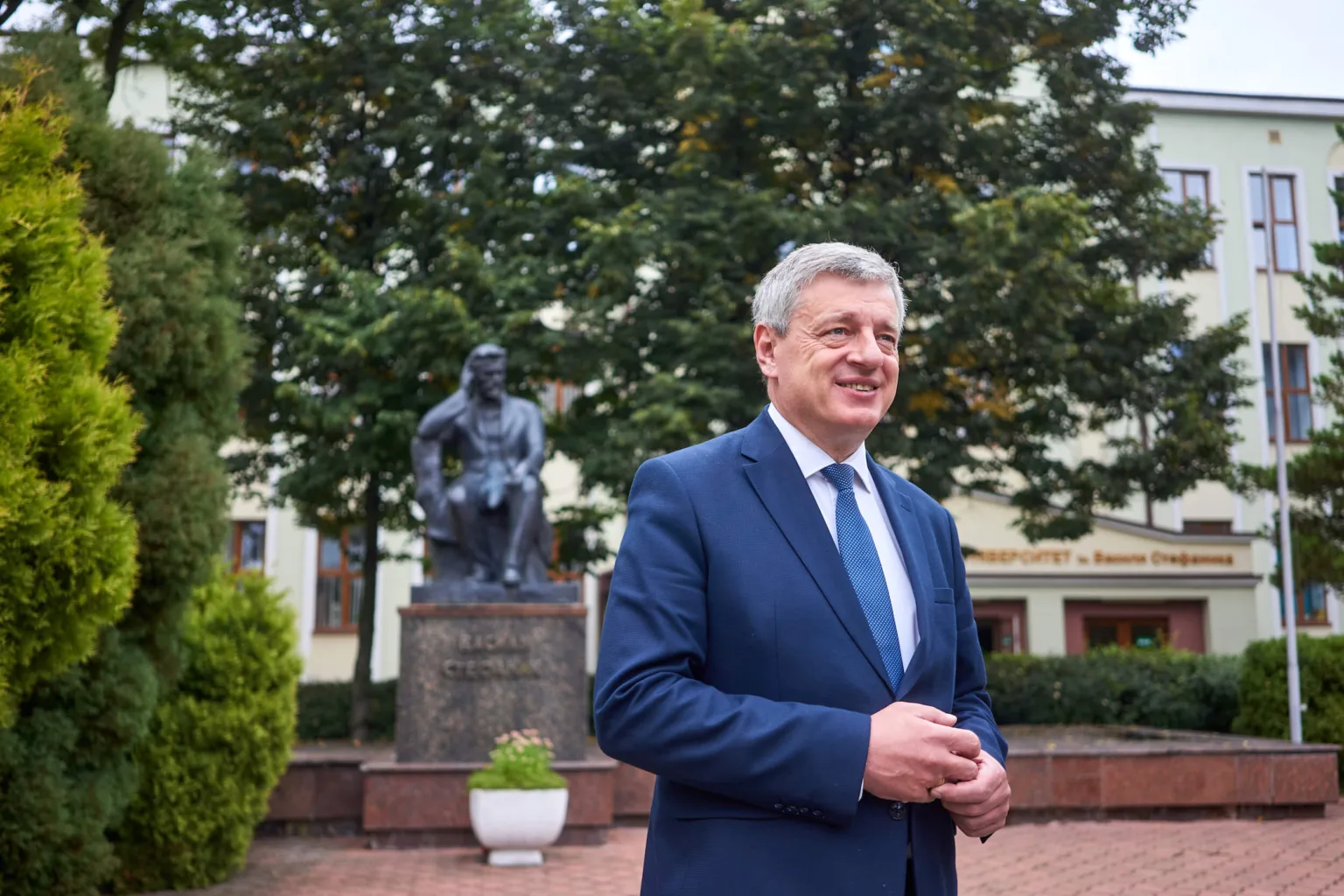 Чоловік у костюмі біля пам'ятника на вулиці