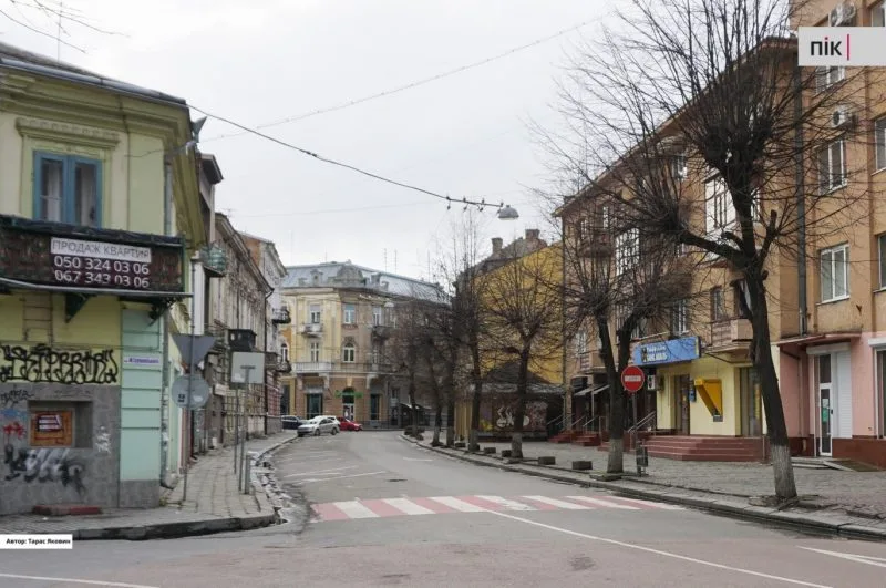Порожня міська вулиця з будинками та деревами