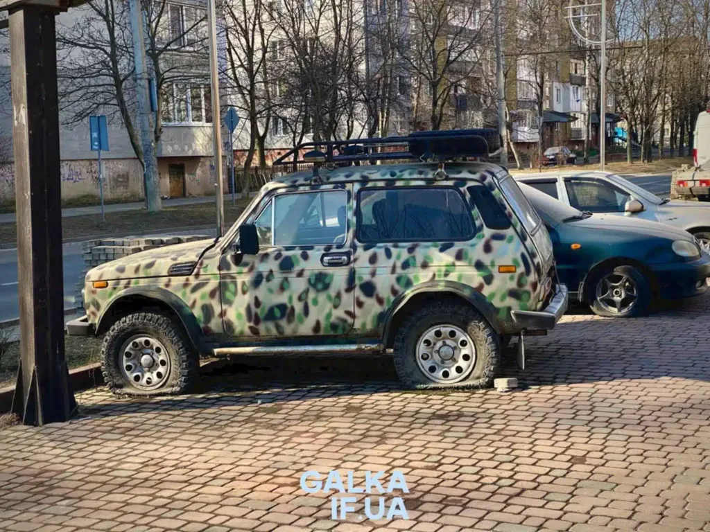 Автомобіль Нива з камуфляжним забарвленням на парковці