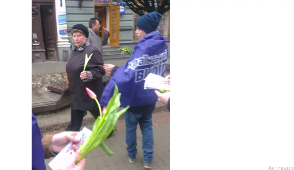 Люди на вулиці роздають тюльпани перехожим