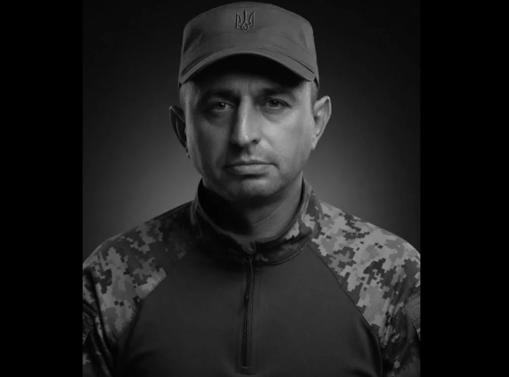 Український військовий у камуфляжі на темному фоні