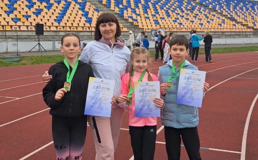 Діти з медалями та дипломами на стадіоні