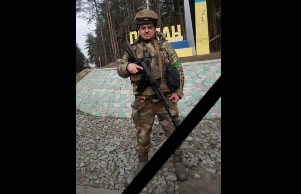 Український військовий у формі стоїть біля лісу