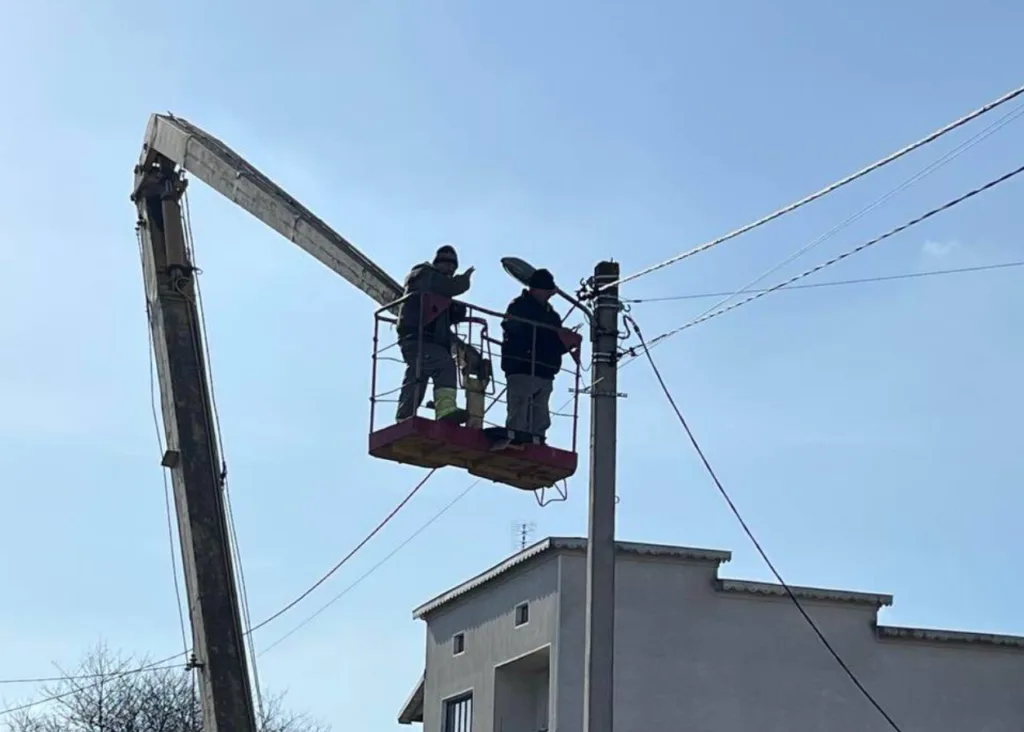 Робітники ремонтують вуличне освітлення на підйомнику
