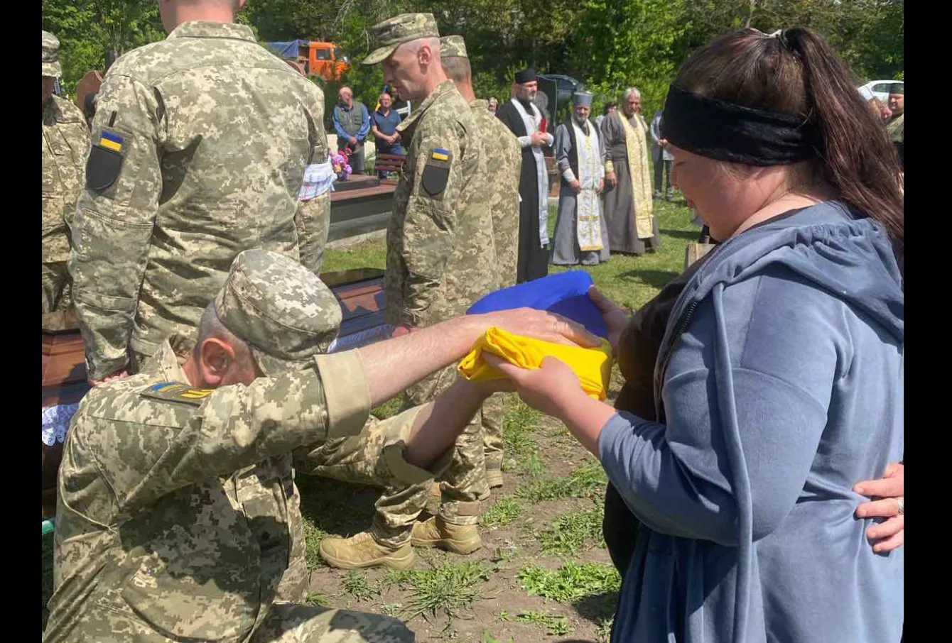 Військовий передає прапор жінці під час церемонії