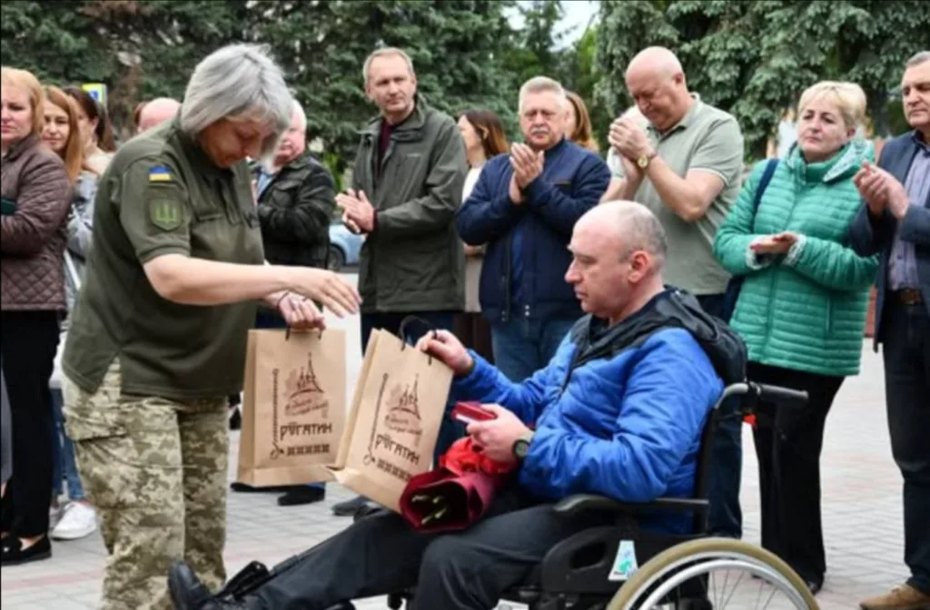 Військова передає подарунки ветерану у візку
