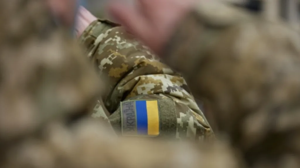 Український військовий у камуфляжі з прапором України