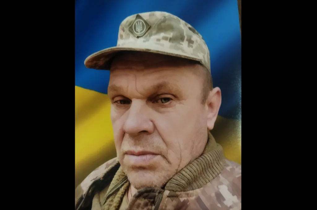 Військовий у камуфляжі на тлі прапора України