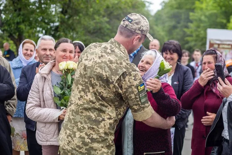 Військовий обіймає літню жінку під час зустрічі