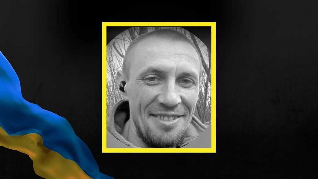 Чорно-біле фото усміхненого чоловіка на темному тлі