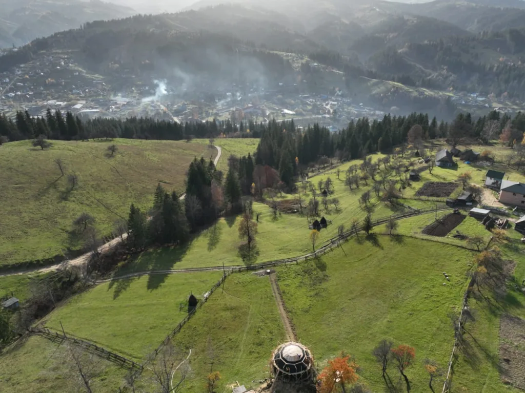 Карпатський пейзаж із горами, селом і зеленими луками